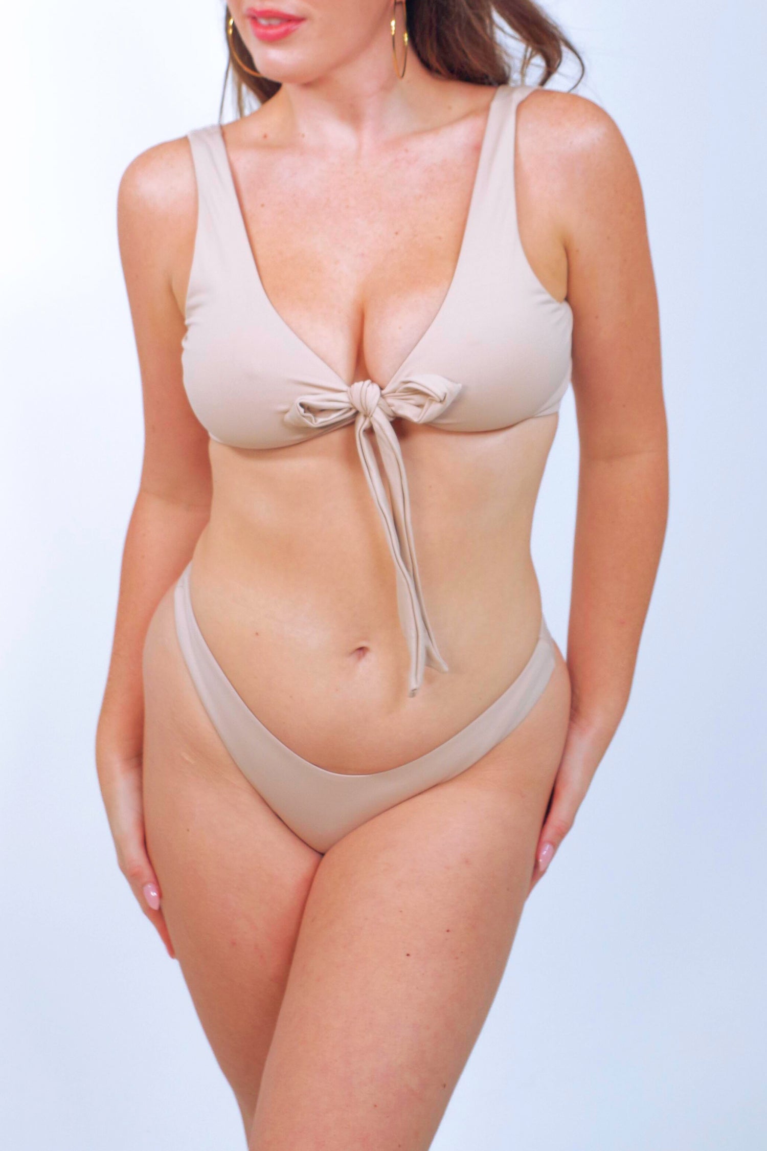 Women's cream bikini top with plunge neckline tied in the front and cheeky bikini bottoms